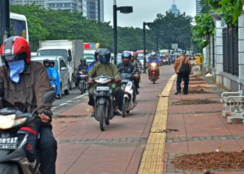 pengendara motor di trotoar