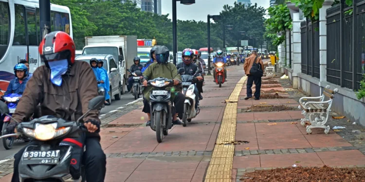 pengendara motor di trotoar